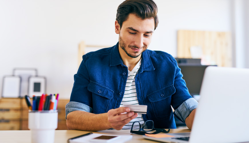 man with credit card shopping on laptop