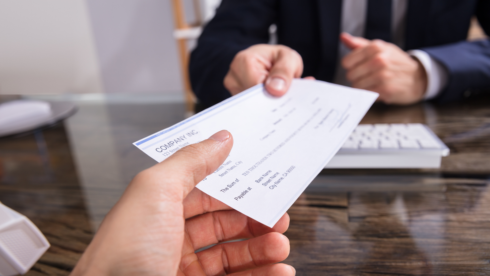 A person's hand giving another person's hand a check to use Branch Capture. 