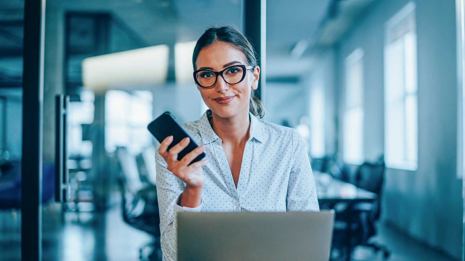 A woman holding a cell phone after using Branch Capture.